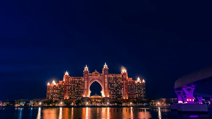 a large building lit up at night over a body of water